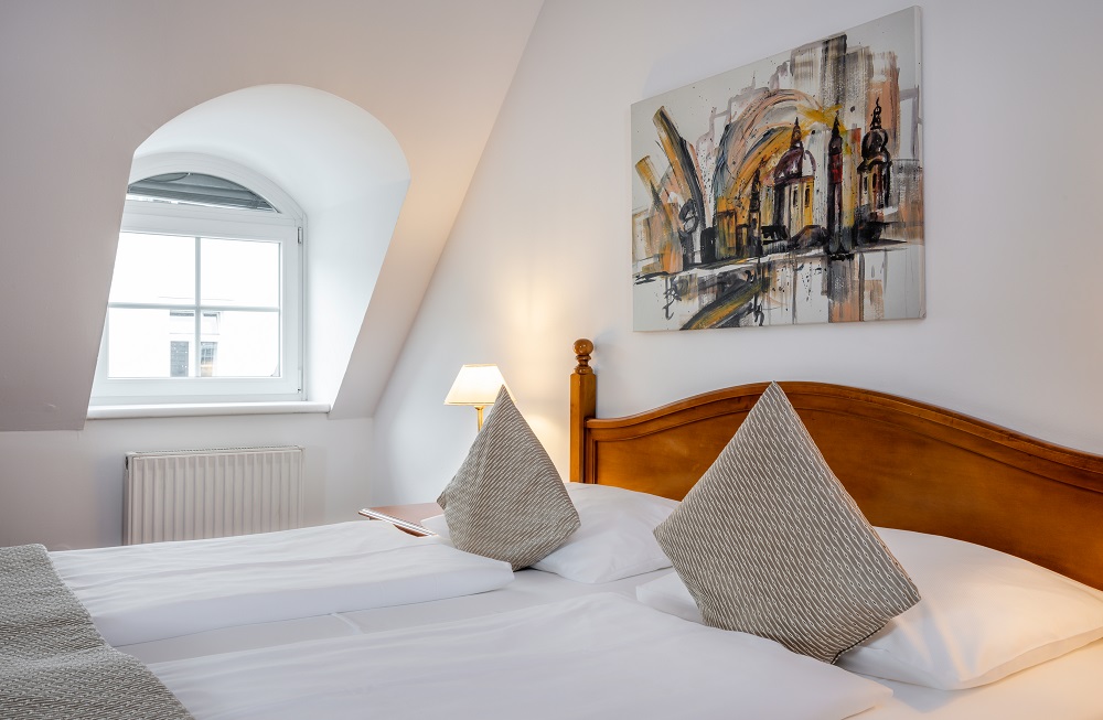Stadthotels - barrierefrei - Standard Doppelzimmer mit heimeligem Wohncharakter und Salzburger Flair. Eine harmonische Komposition aus Farben, Mustern und Stoffen verleiht den historischen Räumen ein behagliches Ambiente.  - Hotel am Mirabellplatz