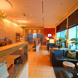 Hotel: Lobby mit gemütlicher Sitzmöglichkeit - H+ Hotel Salzburg